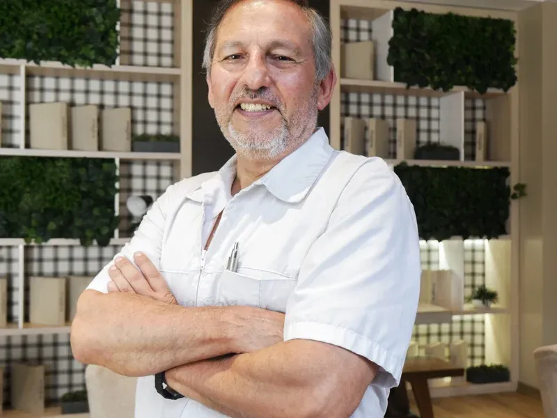 Dr. Óscar Barriga de pie en el consultorio con los brazos cruzados